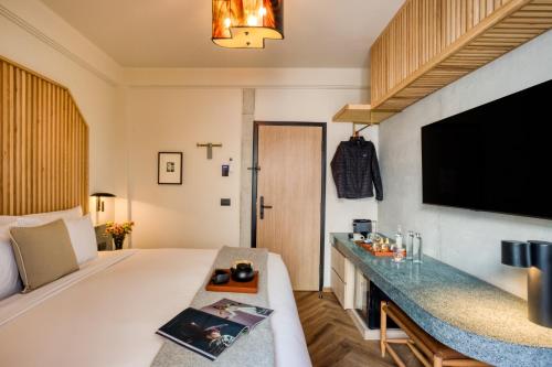 a hotel room with a bed and a flat screen tv at Rodona Hotel in Mexico City