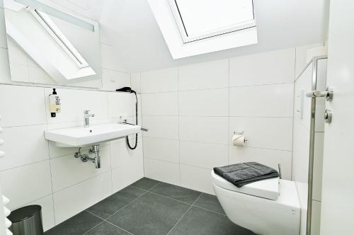 ホーヴァハトにあるDie-Strandburg-Moewenwegの洗面台とトイレを備えた白いバスルーム