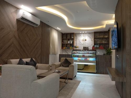 Una sala de estar con un sofá y un televisor. en فندق العابرة الرياض, en Riad