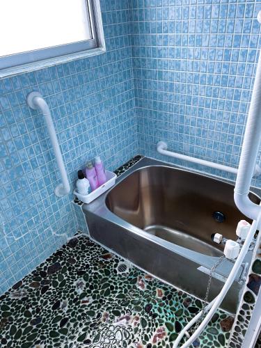 a bath tub in a bathroom with blue tiles at My STAGE in Asahikawa