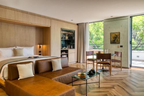 a bedroom with a bed and a couch and a table at Rodona Hotel in Mexico City