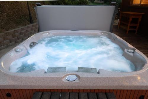 a jacuzzi tub sitting on a deck at Sierra Mountain Escape - Brand new spa/game room! in Yosemite Forks