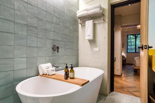 a bathroom with a bath tub with bottles and towels at Rodona Hotel in Mexico City