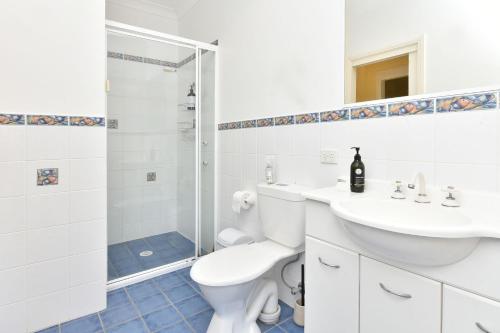 Un baño con inodoro, lavabo y ducha. en Salt and Paws at Fingal Bay, en Fingal Bay