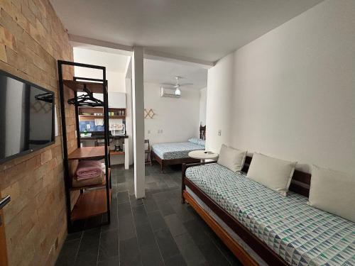 Habitación pequeña con 2 camas y estante en APART STUDIOS PONTAL - Aeroporto 400 m - Centro 2,5 Km - Praia 1,5 Km, en Ilhéus