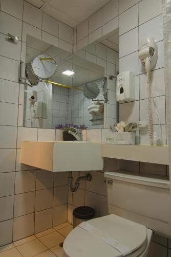 ein Badezimmer mit Toilette und Spiegel in der Unterkunft Hotel Italia Cuenca - Tranvia Centro & Aeropuerto in Cuenca