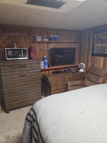 a bedroom with a bed and a tv on a wooden cabinet at Cozy Hideaway in Lewiston