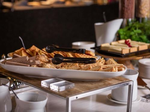 Una mesa cubierta con una bandeja de pan y galletas. en Movenpick Hotel Tallinn, en Tallin