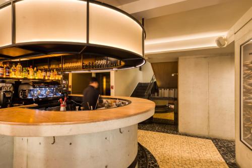 a bar in a restaurant with a man sitting at a counter at Rodona Hotel in Mexico City