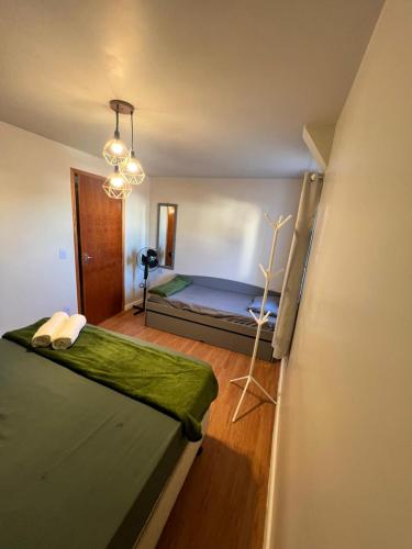 a bedroom with a bed with a green blanket at APTO 401 - no centro, pertinho de tudo in Poços de Caldas