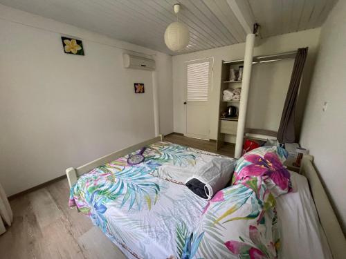 a bedroom with a bed with a colorful comforter at Hotu's Bungalow in Papeete
