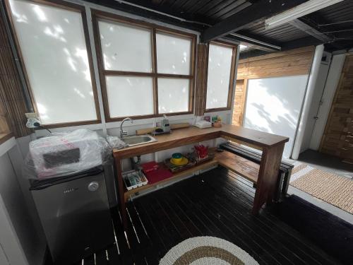 a kitchen with a sink and a counter with windows at Hotu's Bungalow in Papeete