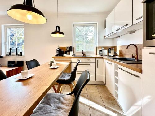 a kitchen with a wooden table and black chairs at Whg Dynamique in Zingst