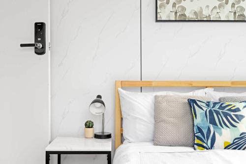 a bedroom with a bed and a table with a lamp at Modern Single Room in Botany - Mins to Airport - Shared Bathroom in Sydney