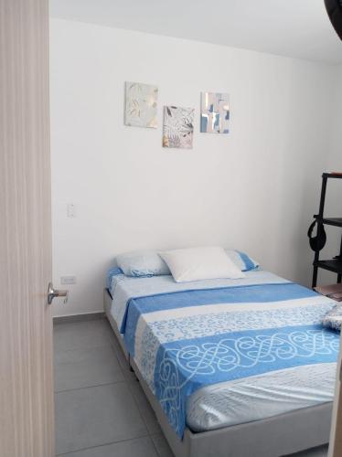 a bedroom with a bed with blue and white sheets at Condomio Alicante Bahia Solero in Ricaurte