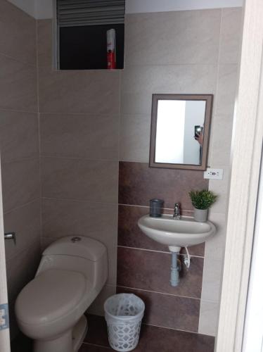 a bathroom with a toilet and a sink and a mirror at Condomio Alicante Bahia Solero in Ricaurte