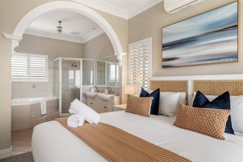 une chambre avec un grand lit blanc et une salle de bain dans l'établissement De'Vinceant - The Grand Manor by Wonnerup Beach, à Geographe