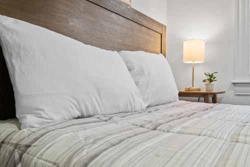 a bed with white pillows and a wooden headboard at Pittsburgh Shadyside 3D Cozy and Stylish Private Bedroom with Shared Bathroom in Pittsburgh