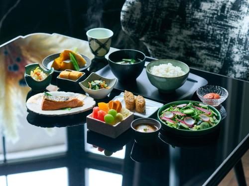a tray of food on a table with bowls of food at Hotel Sosei Sapporo MGallery Collection in Sapporo