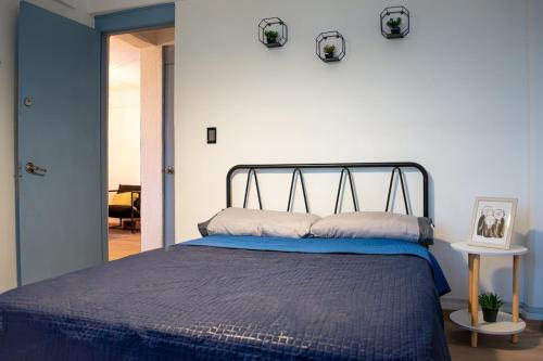 a bedroom with a bed with a blue comforter at Departamento Azul Roma in Cedro