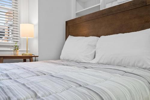 a bedroom with a large bed with a wooden headboard at Pittsburgh Shadyside 3E Stylish and Bright Private Bedroom with Shared Bathroom in Pittsburgh