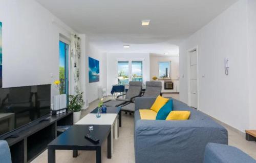 a living room with a blue couch and yellow pillows at Nice Home In Privlaka in Glavan