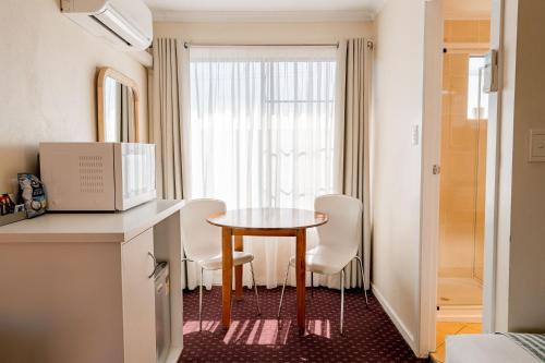 a small room with a table and chairs and a window at The Henry Parkes Tenterfield in Tenterfield