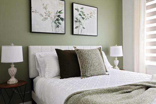 - une chambre avec un lit blanc et 2 lampes dans l'établissement Kinglet 4BR Getaway AC Garage Near WEM DisneyPlus, à Edmonton