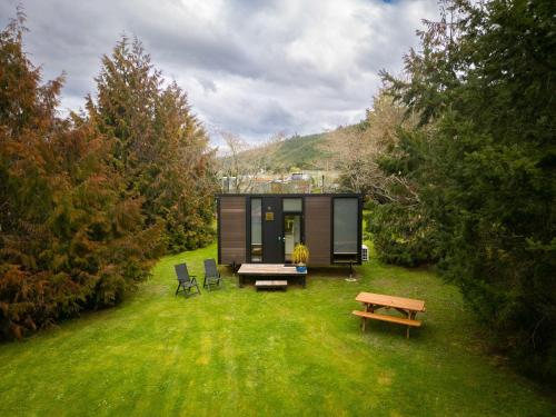 a black tiny house in the middle of a field at Ryan's Ranch by Tiny Away in Belgrove
