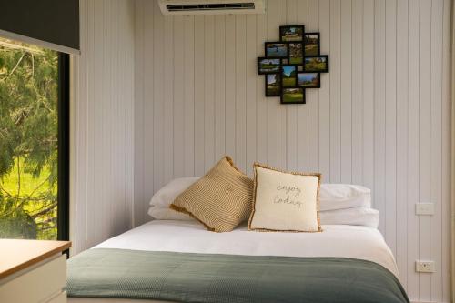 a bedroom with a bed with white pillows and a window at Ryan's Ranch by Tiny Away in Belgrove