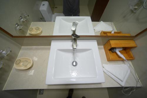 a bathroom counter with a sink and two mirrors at Hathaa Beach Maldives in Hulhumale