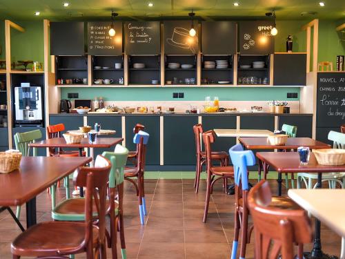 ベルヴィル・シュル・ソーヌにあるgreet Hotel Belleville en Beaujolais A6のテーブルと椅子とカウンターのあるレストラン