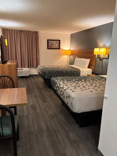 une chambre d'hôtel avec deux lits et une table dans l'établissement Econo Lodge Yazoo City, à Yazoo City