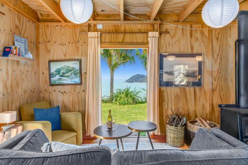a living room with a couch and a table and a window at The Gatehouse - Tata Headlands in Tata Beach
