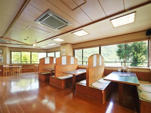 a restaurant with wooden tables and chairs and windows at Hakonenomori Okada in Hakone