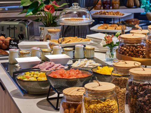 ein Buffet mit vielen verschiedenen Speisen auf einem Tisch in der Unterkunft Mercure Paris Nanterre in Nanterre
