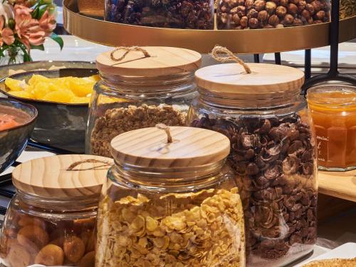 eine Gruppe mit Nüssen und getrockneten Früchten gefüllter Gläser in der Unterkunft Mercure Paris Nanterre in Nanterre