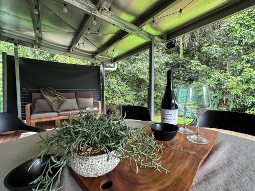 una mesa con una botella de vino y una planta en Atherton Tiny - Retreat with Fire Pit, en Atherton