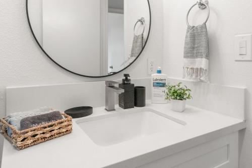a bathroom with a white sink with a mirror at ASU-Mesa Getaway-Stylish & Relaxing in Mesa