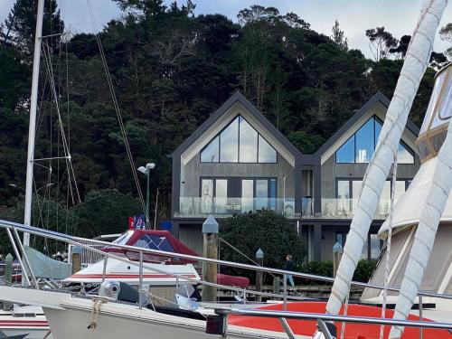 a boat is docked in front of a house at Luxury Waterfront Marina Apartment - Bay of Islands, New Zealand in Opua