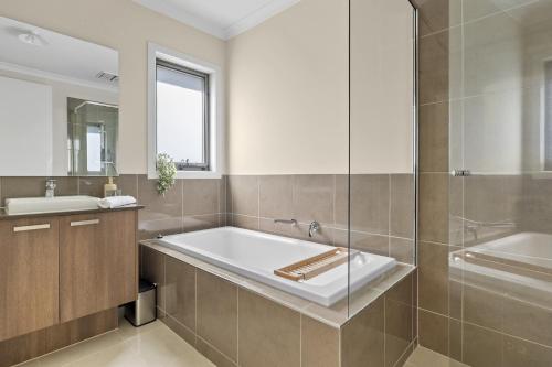 a bathroom with a tub and a sink at Family Retreat with Garden and Parking in Melbourne