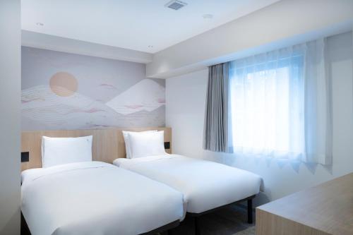 a hotel room with two beds and a window at Garner Hotel Kyoto Shijo Karasuma by IHG in Kyoto