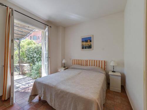 a bedroom with a bed and a sliding glass door at Holiday flats at Domaine de Saint-Endréol with golf, SPA and pool in La Motte