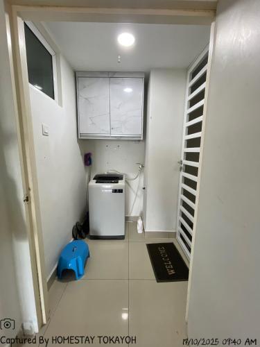 a small kitchen with a small refrigerator and a window at TOKAYOH D Khadijah in Kota Bharu