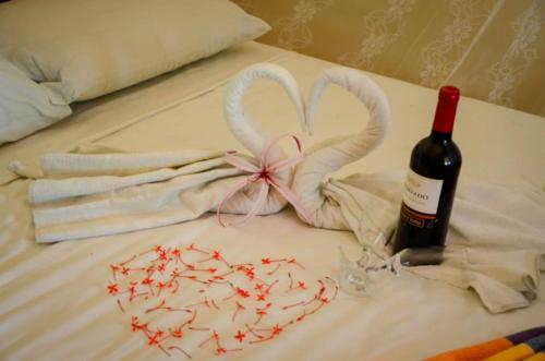 a bed with a bottle of wine and some towels at Pousada Sitio Phoenix in Prea