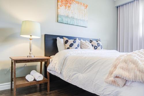 a bedroom with a bed and a table with a lamp at Nest in the Orchard--cozy room in Toronto