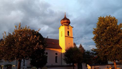 a church with a tower with a clock on it at Appartementhaus Grill in Strobl