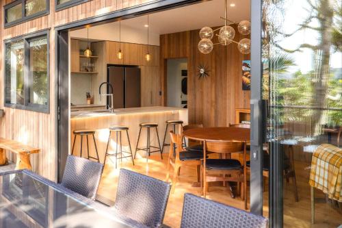Waiheke IslandにあるTe Toki Treehouse and Studioのオープンキッチン、ダイニングルーム(テーブル、椅子付)