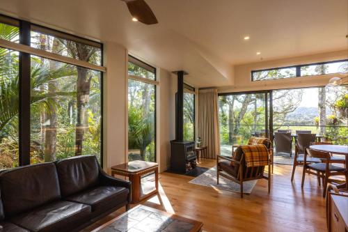 a living room with a couch and a table at Te Toki Treehouse and Studio in Waiheke Island