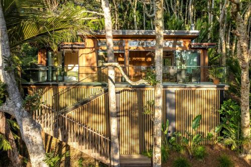Waiheke IslandにあるTe Toki Treehouse and Studioの森の中にある門のある木製の柵